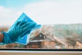 Employee hand in rubber protective glove with micro fiber cloth wiping window from dust. copy space, General cleaning Royalty Free Stock Photo