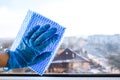 Employee hand in rubber protective glove with micro fiber cloth wiping window from dust. copy space, General cleaning