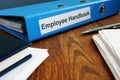 Employee Handbook manual in folder and papers