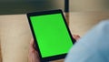 Employee hands holding mockup tablet in office closeup. Greenscreen pad close up