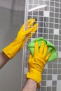 Employee hands in rubber protective gloves with rag washing and polishing a shower cabin doors. Cleaning concept