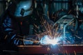 An employee or heavy industrial worker inside factory with industrial worker using welding machine. Industrial safety first