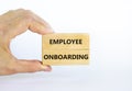 Employee onboarding success symbol. Wooden blocks with words `Employee onboarding` on beautiful white background. Businessman ha