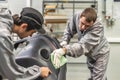 An employee of the paint shop of the automobile plant conducts training on the preparation of bumpers for painting