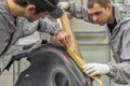 An employee of the paint shop of the automobile plant conducts training on the preparation of bumpers for painting