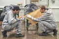 An employee of the paint shop of the automobile plant conducts training on the preparation of bumpers for painting