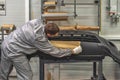 An employee of the paint shop of the automobile plant prepares bumpers for painting