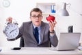 The employee with piggybank in time management concept Royalty Free Stock Photo