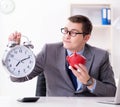 Employee with piggybank in time management concept Royalty Free Stock Photo