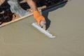 An employee plasters wet concrete cement floor using a trowel after concrete has just been poured Royalty Free Stock Photo