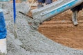 An employee is pouring wet concrete at a new construction site on the site of a near new home in order to pave a Royalty Free Stock Photo