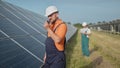 An employee of a power plant transmits commands by walkie-talkie. Happy caucasian adult engineer in helmet smiling at