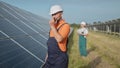 An employee of a power plant transmits commands by walkie-talkie. Happy caucasian adult engineer in helmet smiling at