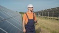 An employee of a power plant transmits commands by walkie-talkie. Happy caucasian adult engineer in helmet smiling at