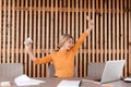 Employee pretty young woman relax in workplace. Stretching her arms Royalty Free Stock Photo