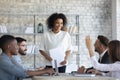 Employee raising hand, asking question to African American business coach Royalty Free Stock Photo