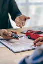 Employee of the rental car company handing over the keys to the renter after discussing the details and conditions