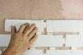 The employee`s hand presses the decorative tiles against the finishing wall on the mortar. tile laying technology