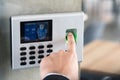 Employee scanning fingerprint record hours work time