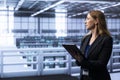Employee in server room monitoring supercomputers equipment with tablet