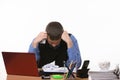 Employee sits clasping his head with his fists at the office table