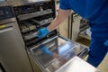 Employee of a surgical department loads a washing machine with used surgical instruments Royalty Free Stock Photo