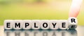 From an employee to an employer. Hand turns a dice and changes the word `employee` to `employer`. Royalty Free Stock Photo