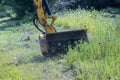 An employee of utility company mowing tall grass along side of a road using a professional tractor mechanical mower cut