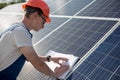 Employee working with drawings on solar energy station.