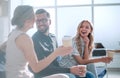 Employees of the company with coffee glasses sitting in the office lobby