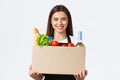 Employees, delivery and online orders, grocery stores concept. Friendly-looking pleasant young saleswoman handling over