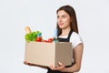 Employees, delivery and online orders, grocery stores concept. Profile of nice cute saleswoman, cashier in black apron