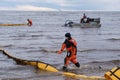 Employees of the environmental service clean up after low tide on the coast Gulf of Finland remove garbage, oil spills, harmful