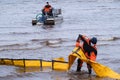 Employees of the environmental service clean up after low tide on the coast Gulf of Finland remove garbage, oil spills, harmful