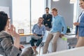 Employees gather in the office and listen to their colleague speak