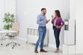 Employees having break near water cooler in office Royalty Free Stock Photo