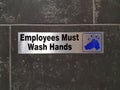 Employees must wash hands sign on bathroom wall