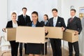 Employees in office holding cardboard boxes