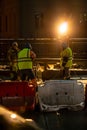 Employees of the road service in special yellow vests perform work on the repair of the roadway. Restoration of the deformation