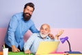 Employees sit at office desk look at laptop screen cooperating in office. Couple of two office workers working at laptop Royalty Free Stock Photo