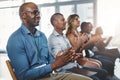 Employees sitting and clapping together in a seminar and successful workshop. Diverse workplace that support the staff