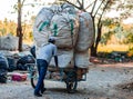 Employees sorting garbage, are throwing large garbage bags to destroy