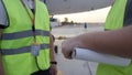 Employees in yellow dickey shake hands. Airport workers shakes hands. Engineers shake hands after checking. Airport