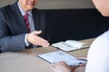 Employer or recruiter holding reading a resume during about colloquy his profile of candidate, employer in suit is conducting a Royalty Free Stock Photo