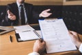 Employer or recruiter holding reading a resume during about his profile of candidate, employer in suit is conducting a job