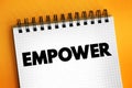 Empower - to give power or authority to, authorize, especially by legal or official means, text concept on notepad Royalty Free Stock Photo