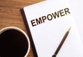 Empower word on paper notebook with cup of coffee, empowerment and leadership concept