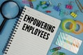 Empowering Employees text with magnifying glass on blue background Royalty Free Stock Photo