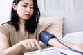 empowering self-care concept with Asian woman conducting regular blood pressure checkups at home