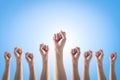 Empowering women power, human rights and labor day concept with strong fist hands  on blue sky Royalty Free Stock Photo